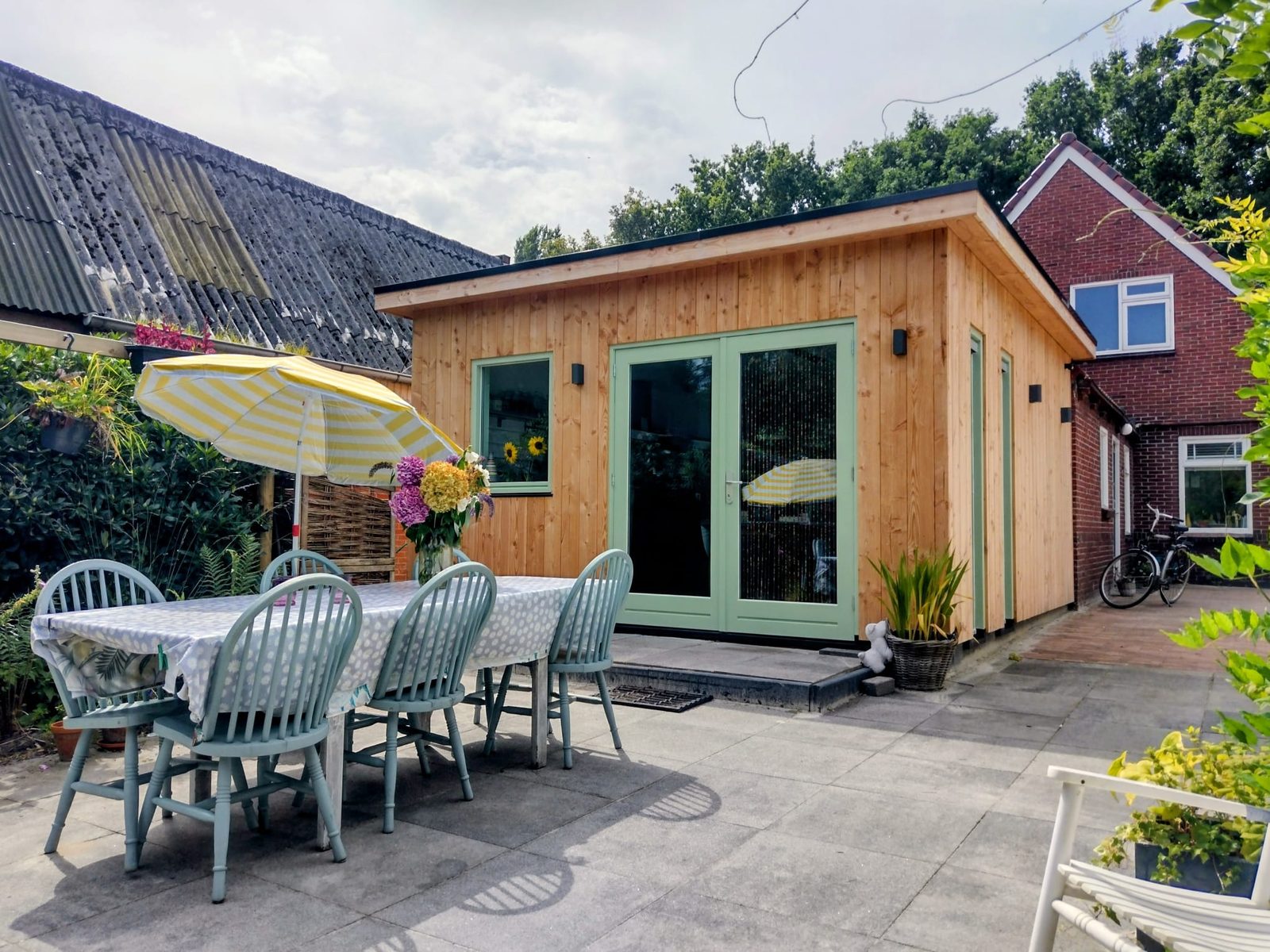 Gerealiseerde houten aanbouw met tuindeuren in Oude Pekela