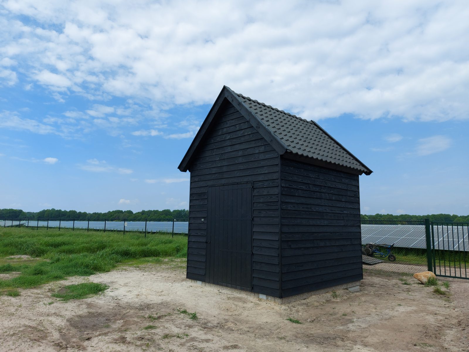 Vrijstaand donker houten gebouw met pannendak in Sleen